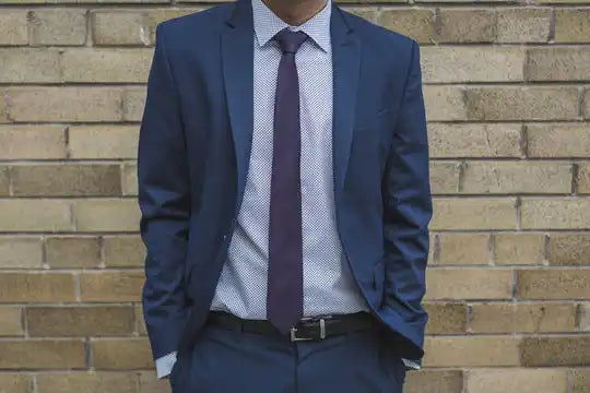 Traje de negocios azul marino con una corbata morada y una camisa de vestir azul claro.
