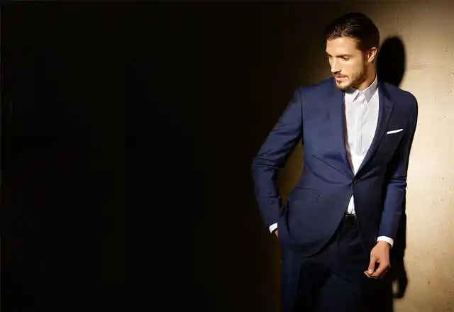 Traje azul marino con una camisa blanca y un pañuelo de bolsillo.